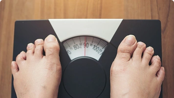 A person wearing oversized jeans and pulling the waistband to show loose fit, symbolizing rapid or unintended weight loss.