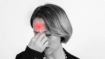 Older woman fanning herself and looking flushed, indicating a hot flash.