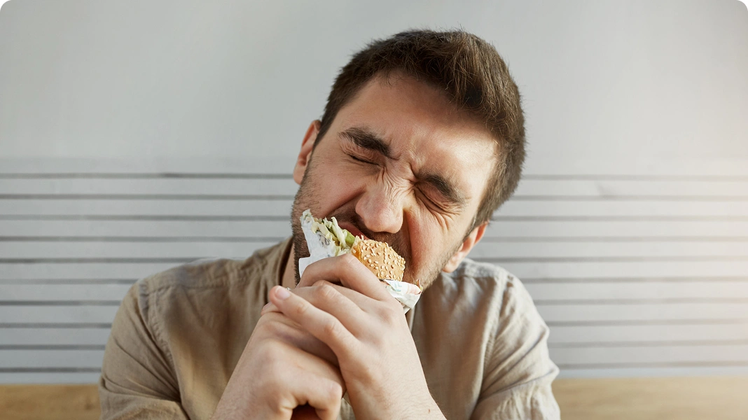 Angry man with empty plate and utensils.